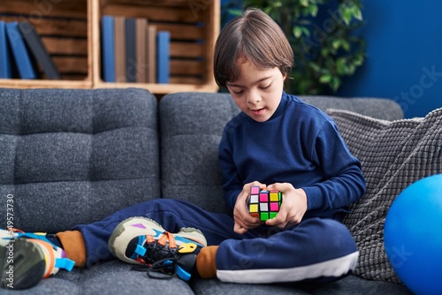 фотографія Down syndrome kid playing with puzzle cube at home