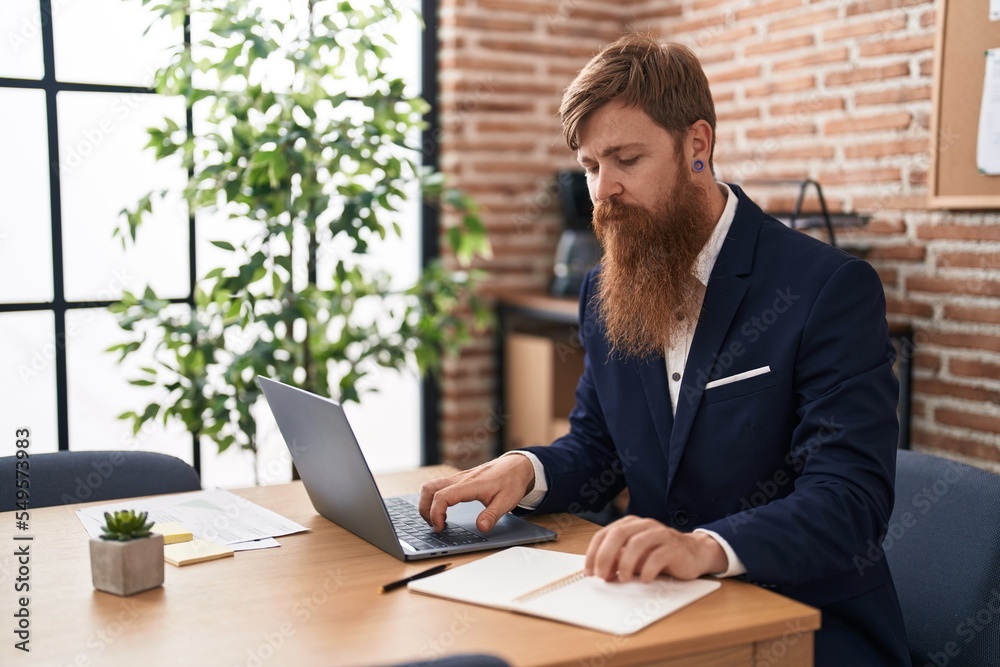 Young redhead man business worker using laptop working at office Young redhead man business worker using laptop working at office