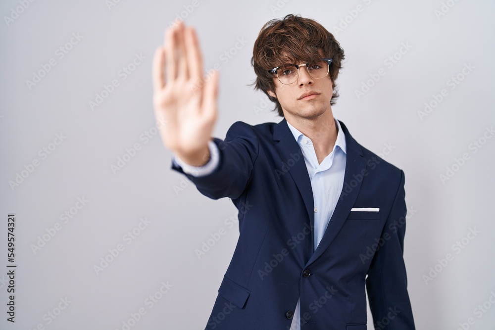 Hispanic business young man wearing glasses doing stop sing with palm of the hand. warning expression with negative and serious gesture on the face. Hispanic business young man wearing glasses doing stop sing with palm of the hand. warning expression with negative and serious gesture on the face.