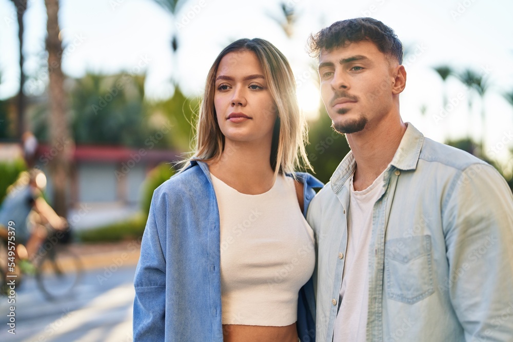 Young man and woman couple hugging each other standing with relaxed expression at street Young man and woman couple hugging each other standing with relaxed expression at street