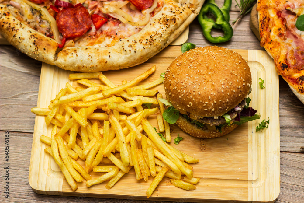 Pizza and hamburger on wooden background Pizza and hamburger on wooden background