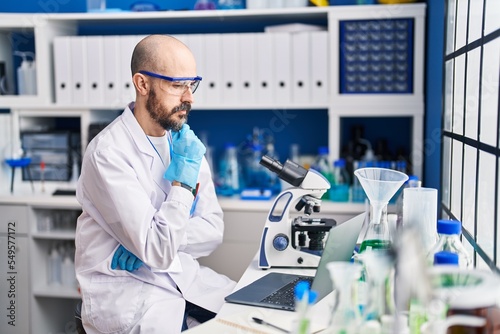 Young bald man scientist having video call at laboratory