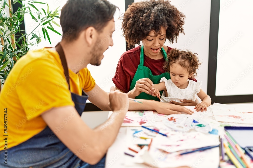Naklejka premium Couple and daughter smiling confident drawing at art studio
