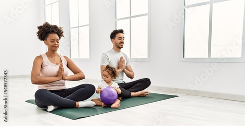Couple and daughter smiling confident training yoga at sport center