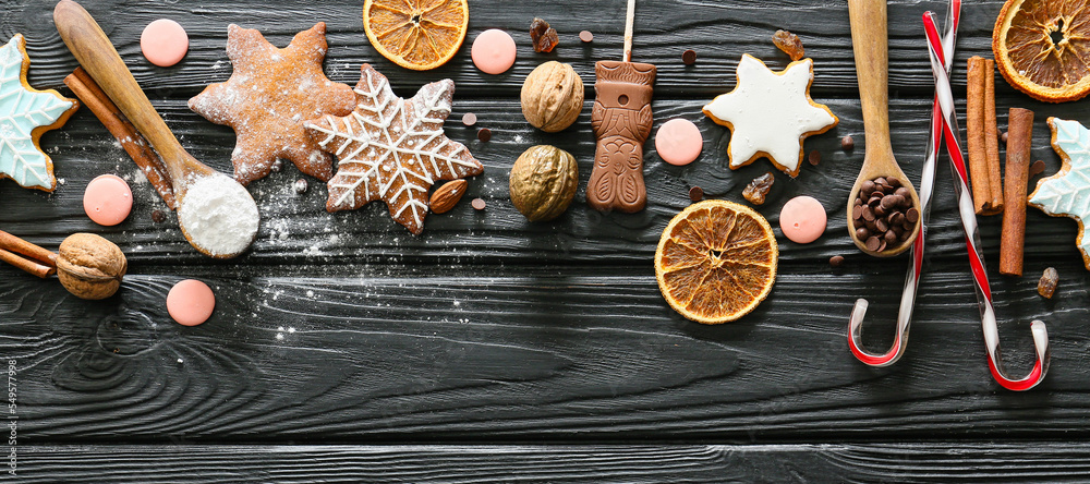 Composition with tasty Christmas cookies and ingredients on dark wooden table Composition with tasty Christmas cookies and ingredients on dark wooden table