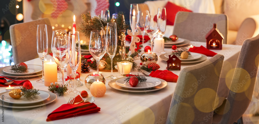 Stylish table setting with burning candles and Christmas decorations in room