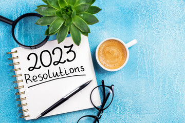 New year resolutions 2023 on desk. 2023 resolutions list with notebook, coffee cup on table. Goals, resolutions, plan, action, checklist concept. New Year 2023 background, copy space