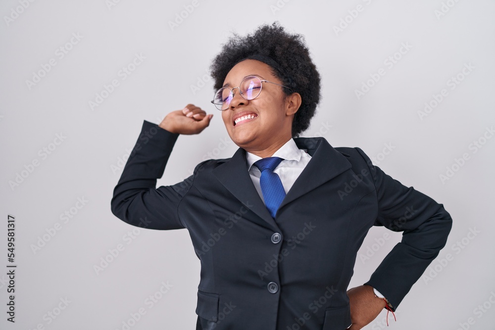 Beautiful african woman with curly hair wearing business jacket and glasses stretching back, tired and relaxed, sleepy and yawning for early morning Beautiful african woman with curly hair wearing business jacket and glasses stretching back, tired and relaxed, sleepy and yawning for early morning