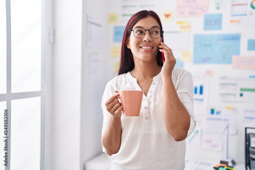 Young beautiful hispanic woman business worker talking on smartphone drinking coffee at office Young beautiful hispanic woman business worker talking on smartphone drinking coffee at office