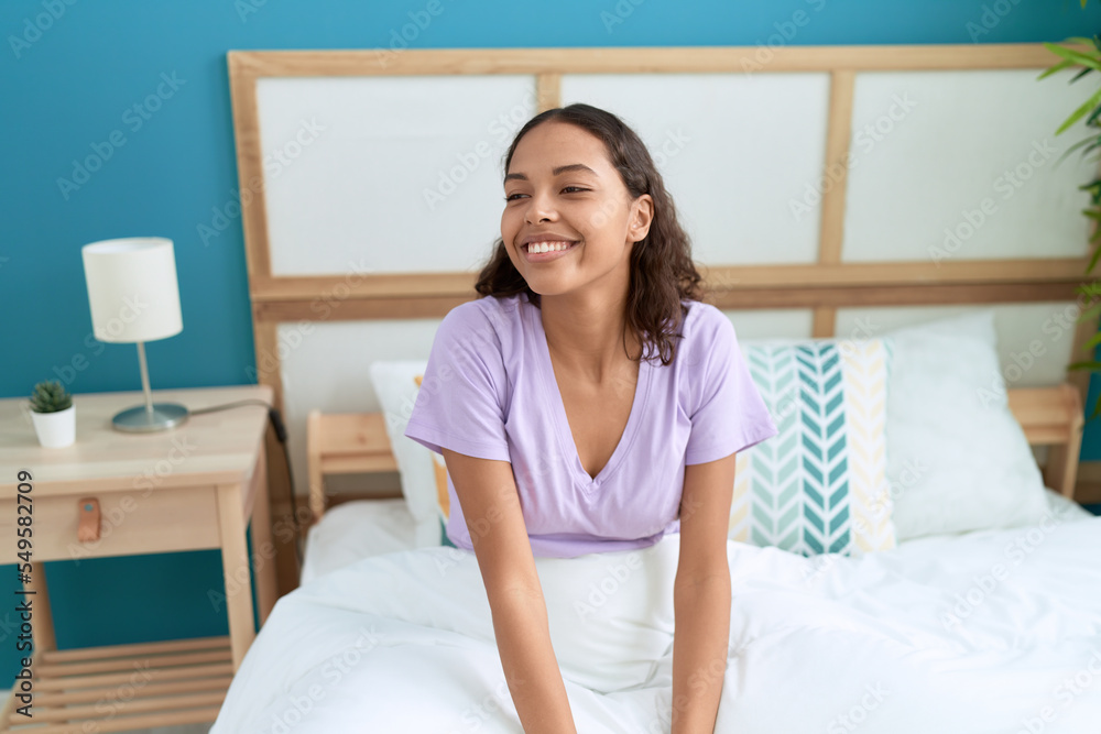 Young african american woman smiling confident sitting on bed at bedroom Young african american woman smiling confident sitting on bed at bedroom