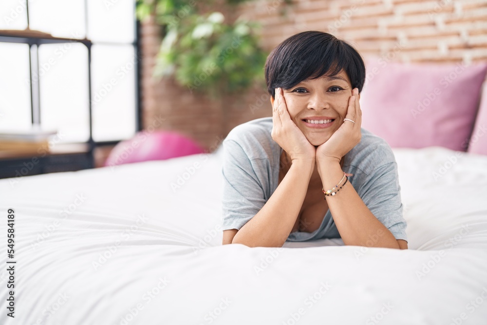 Middle age chinese woman smiling confident lying on bed at bedroom Middle age chinese woman smiling confident lying on bed at bedroom