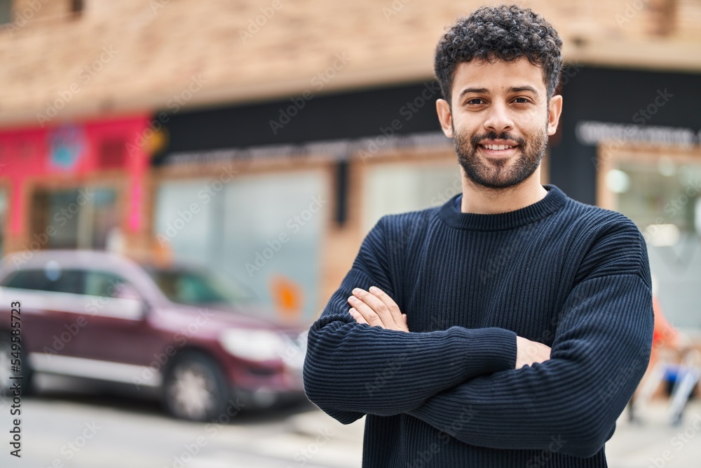 Fototapeta premium Young arab man smiling confident standing with arms crossed gesture at street