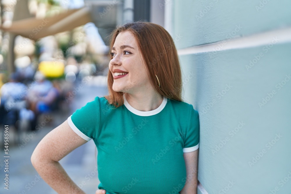Young redhead woman smiling confident looking to the side at street