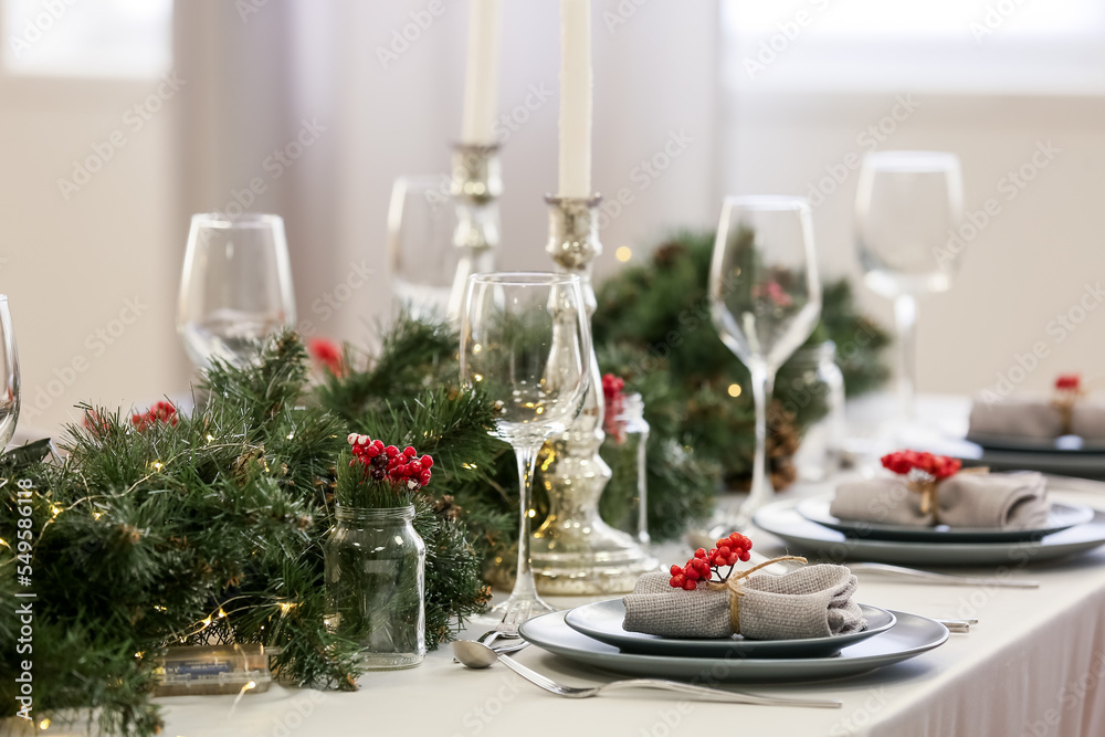 Christmas table setting with fir branches and rowan in dining room, closeup Christmas table setting with fir branches and rowan in dining room, closeup