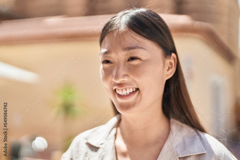 Chinese woman smiling confident looking to the side at street Chinese woman smiling confident looking to the side at street