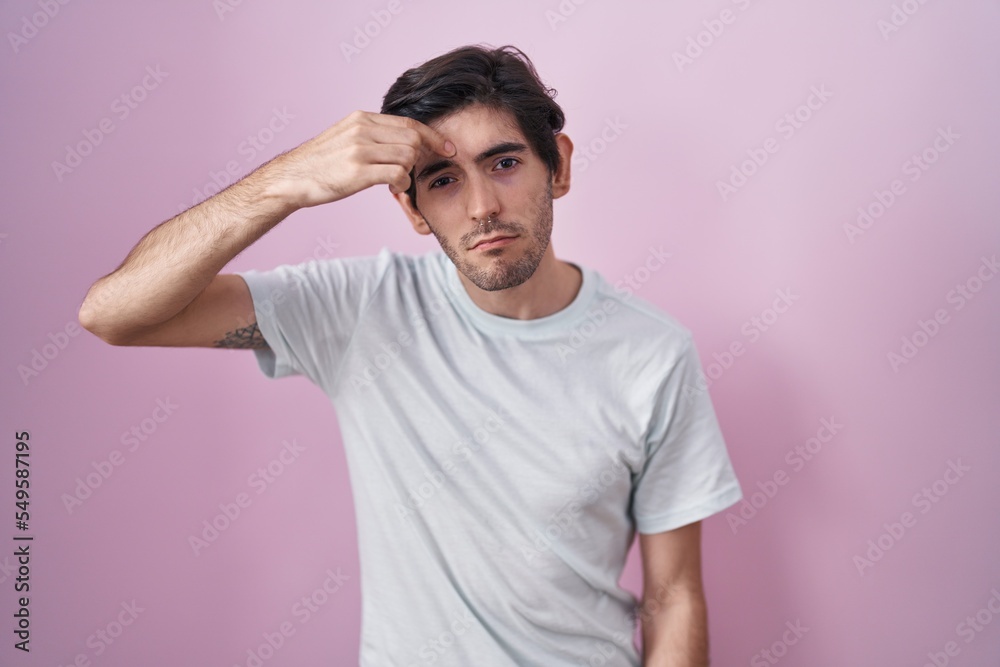 Young hispanic man standing over pink background pointing unhappy to pimple on forehead, ugly infection of blackhead. acne and skin problem Young hispanic man standing over pink background pointing unhappy to pimple on forehead, ugly infection of blackhead. acne and skin problem