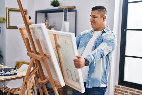 Young latin man artist smiling confident looking draw at art studio