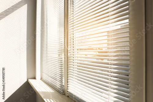 Stylish window with horizontal blinds in room © New Africa