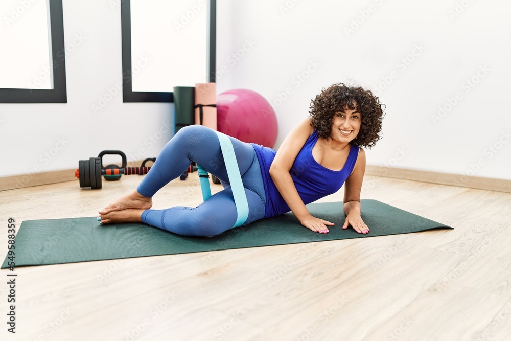 Young middle east woman smiling confident training using elastic band at sport center Young middle east woman smiling confident training using elastic band at sport center