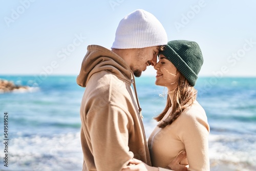 Mand and woman couple smiling confident hugging each other at seaside