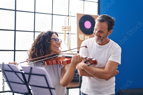 Photos Man and woman violinist having violin lesson at music studio
