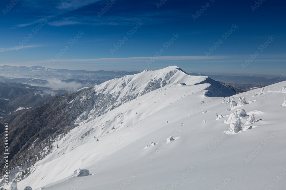 Snowy mountain against the background of a large massive Marmaros mountain range. Winter mountains landscape outdoor concept