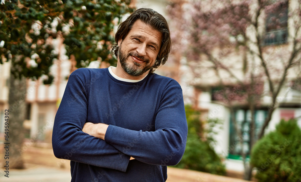 Middle age handsome man smiling with crossed arms outdoors at the park Middle age handsome man smiling with crossed arms outdoors at the park