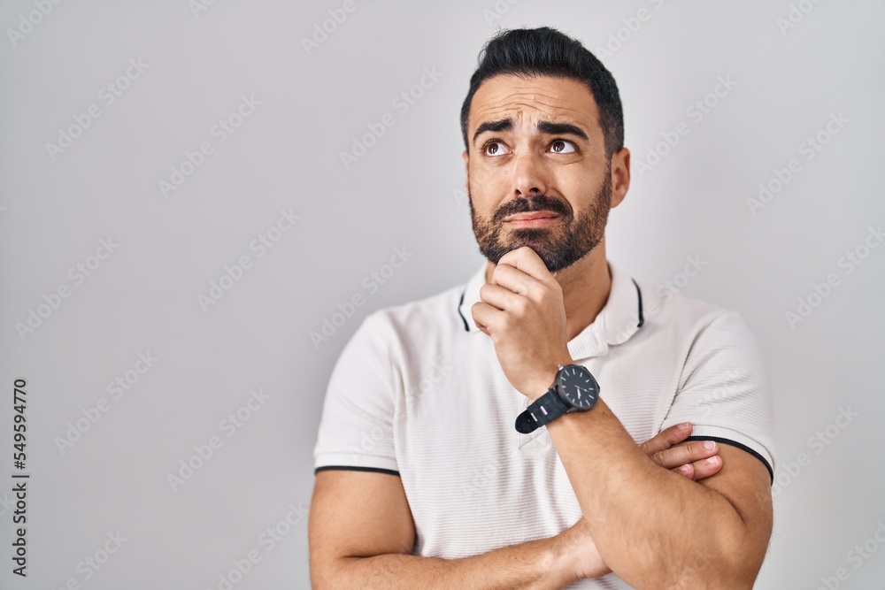 Young hispanic man with beard wearing casual clothes over white background thinking worried about a question, concerned and nervous with hand on chin Young hispanic man with beard wearing casual clothes over white background thinking worried about a question, concerned and nervous with hand on chin
