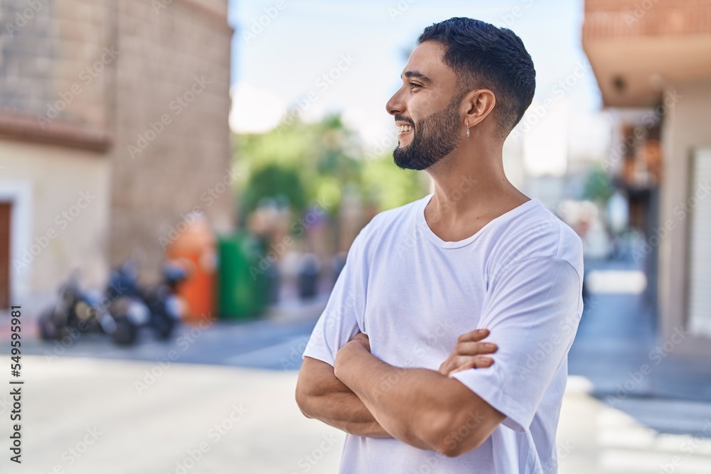 Young arab man standing with arms crossed gesture at street