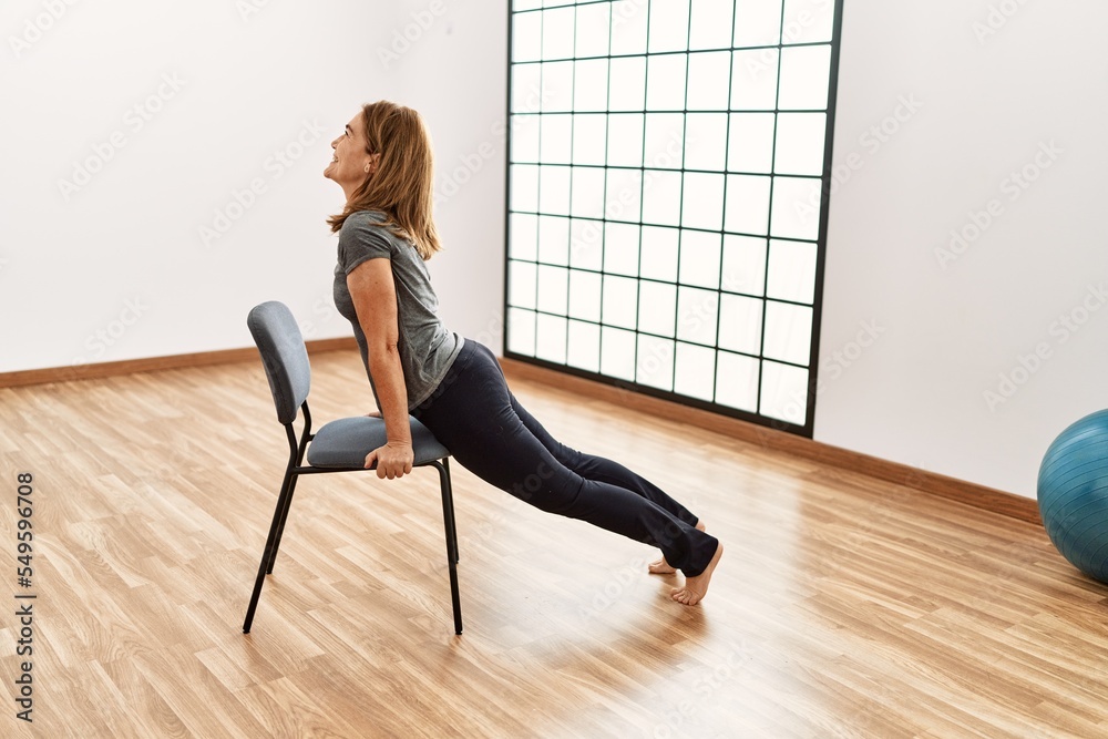 Middle age caucasian woman smiling confident training at sport center