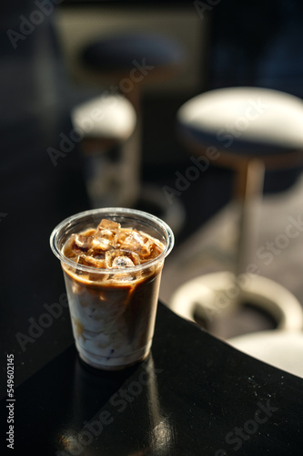 ice latte coffee in plastic glass on black table at cafe   