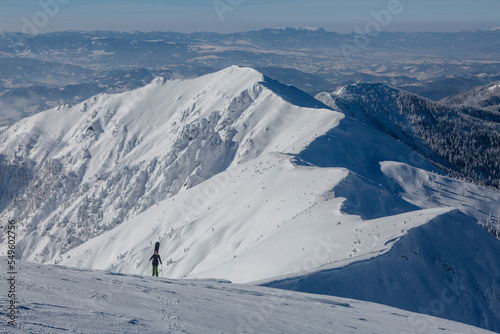 An active female freerider with a snowboard going to the top of the mount