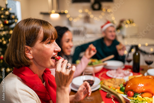 Multi-ethnic big family celebrating Christmas party together in house.