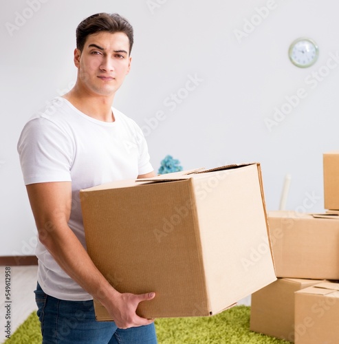 Young man moving boxes at home © Elnur