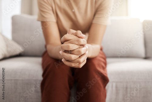 Stress, worry and hands of woman on sofa with mental health issue, problem and anxiety at home. Depression, sadness and close up of connected hand of girl with fear, nervous and stressed expression