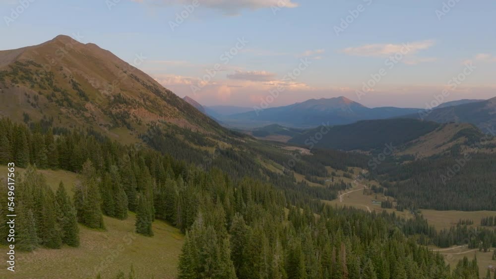Aerial over trees in the Colorado Rockies and towards a mountain peak on the horizon on a beautiful day. Aerial over trees in the Colorado Rockies and towards a mountain peak on the horizon on a beautiful day.