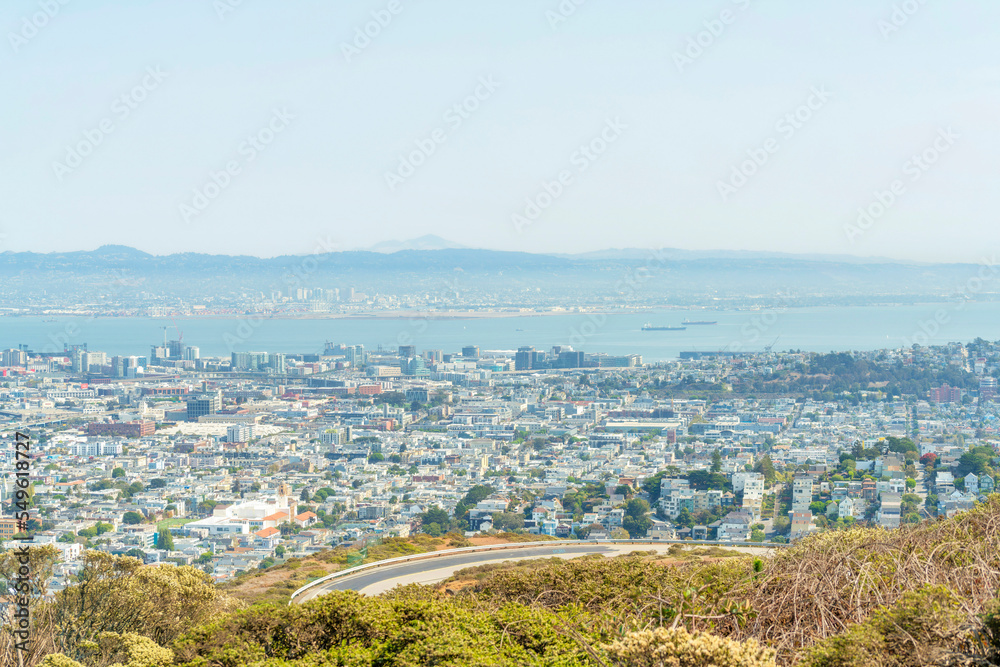 Fototapeta premium winding hillside road with ocean and city background