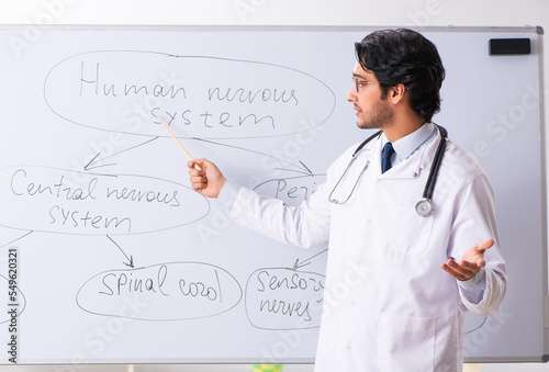 Young male doctor neurologist in front of whiteboard