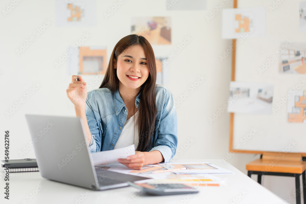 Design building concept, Female architect holding blueprint of house plan and smiling on camera Design building concept, Female architect holding blueprint of house plan and smiling on camera