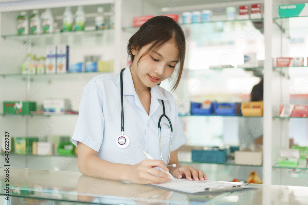 Medicine and health concept, Female pharmacist is checking stock medicine and writing on clipboard Medicine and health concept, Female pharmacist is checking stock medicine and writing on clipboard