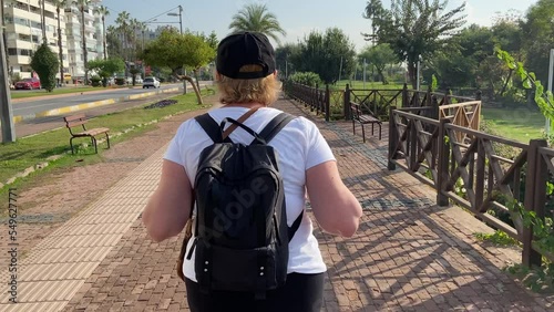 Senior adventureisageless woman with backpack walking on Antalya city Tukey. Summer active tourism for pensioner. photo