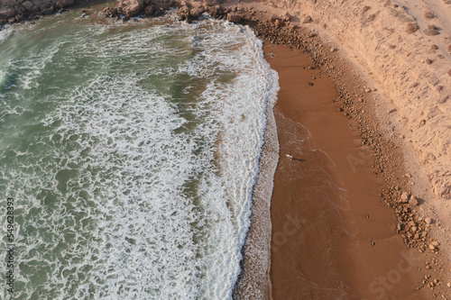 Aerial view of the coastline of Imsouane, Morocco. One surfer is going to the Atlantic Ocean.  photo