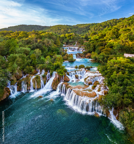 Krka, Croatia - Aerial view of the beautiful Krka Waterfalls in Krka National Park on a bright summer morning with green foliage, turquoise water and blue sky photo