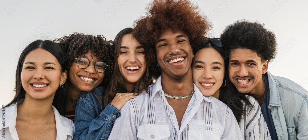 Portraits of multiracial group of young people smiling looking at camera.