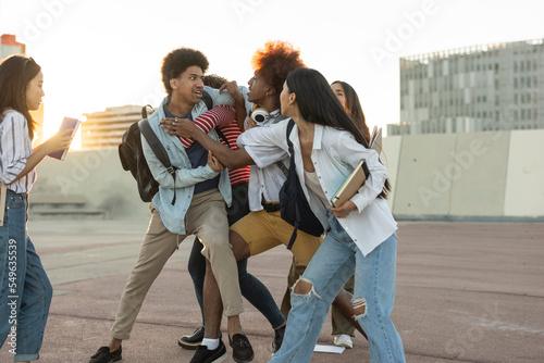 Fényképezés Two men of different ethnicities fight and are separated by their friends
