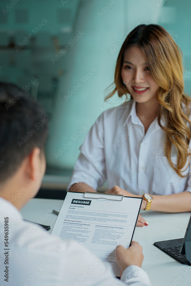 Young man handing resume to employer for job interview to review job application The concept shows the company's ability to agree on job positions, employees. Young man handing resume to employer for job interview to review job application The concept shows the company's ability to agree on job positions, employees.