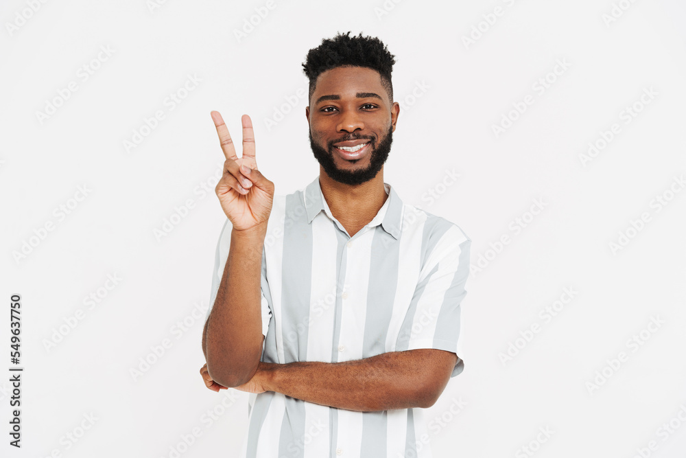 Black bearded man wearing shirt smiling and showing peace sign Black bearded man wearing shirt smiling and showing peace sign