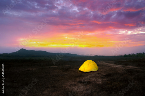 Camping with Yellow tent under the beautiful sky in the morning before the sunrise, Lampang, Thailand.