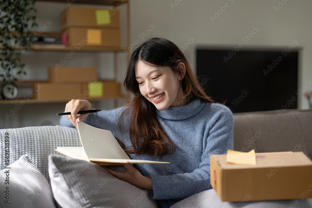 Starting small businesses SME owners woman entrepreneurs taking note for check online orders to prepare to pack the boxes, sell to customers, sme business ideas online Starting small businesses SME owners woman entrepreneurs taking note for check online orders to prepare to pack the boxes, sell to customers, sme business ideas online