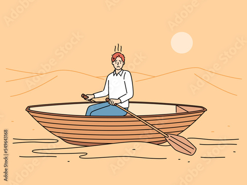 Stressed man rowing in desert